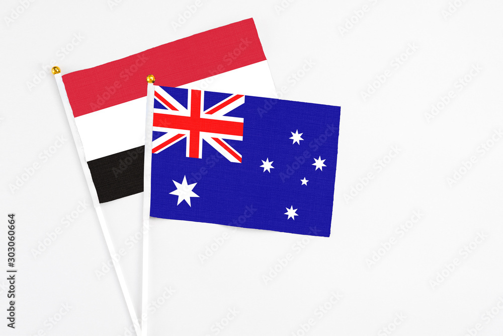 Fototapeta premium Australia and Yemen stick flags on white background. High quality fabric, miniature national flag. Peaceful global concept.White floor for copy space.