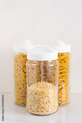 different types of pasta in glass jars close up isolate