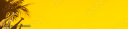 Fototapeta postać zwierzęcia na żółtym tle. Cień palmy i żyrafa. Skopiuj miejsce Transparent