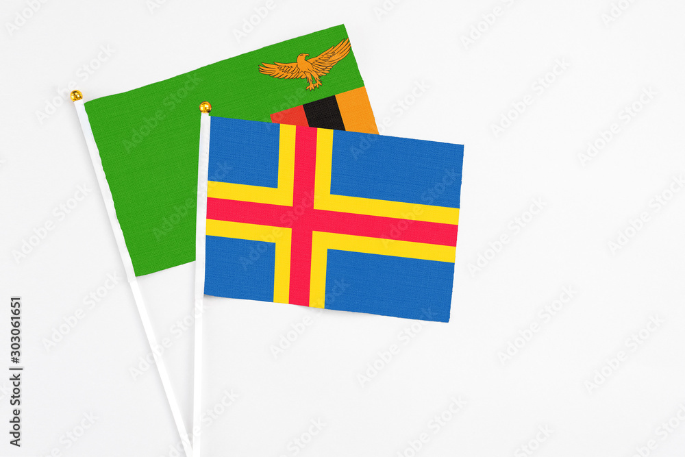 Aland Islands and Zambia stick flags on white background. High quality fabric, miniature national flag. Peaceful global concept.White floor for copy space. Aland Islands and Zambia stick flags on white background. High quality fabric, miniature national flag. Peaceful global concept.White floor for copy space.