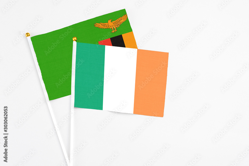 Ireland and Zambia stick flags on white background. High quality fabric, miniature national flag. Peaceful global concept.White floor for copy space. Ireland and Zambia stick flags on white background. High quality fabric, miniature national flag. Peaceful global concept.White floor for copy space.