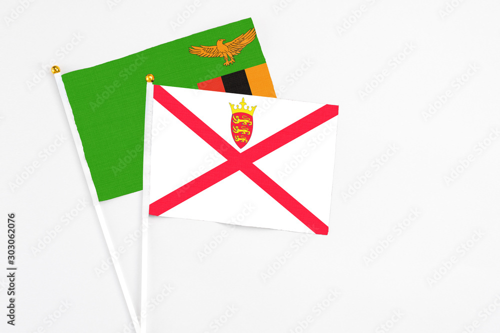 Jersey and Zambia stick flags on white background. High quality fabric, miniature national flag. Peaceful global concept.White floor for copy space. Jersey and Zambia stick flags on white background. High quality fabric, miniature national flag. Peaceful global concept.White floor for copy space.