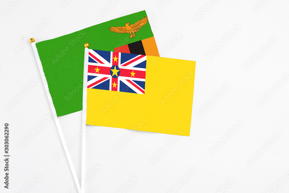 Niue and Zambia stick flags on white background. High quality fabric, miniature national flag. Peaceful global concept.White floor for copy space. Niue and Zambia stick flags on white background. High quality fabric, miniature national flag. Peaceful global concept.White floor for copy space.