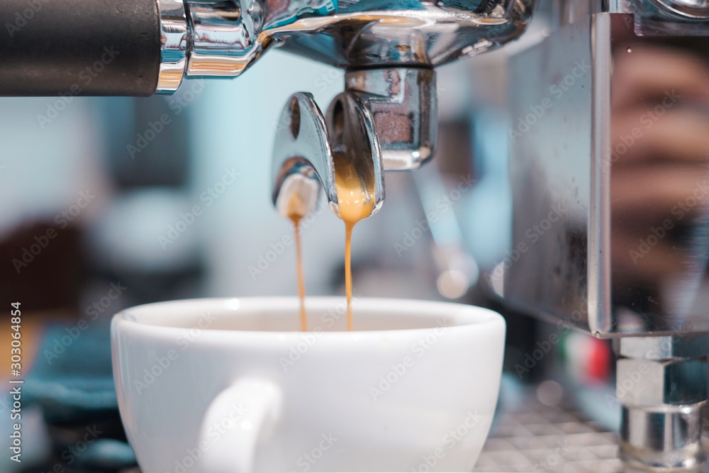 Coffee drips into coffee cup from Espresso Machine Coffee drips into coffee cup from Espresso Machine
