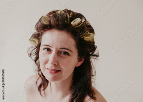 Beautiful brown-haired woman with hair curlers