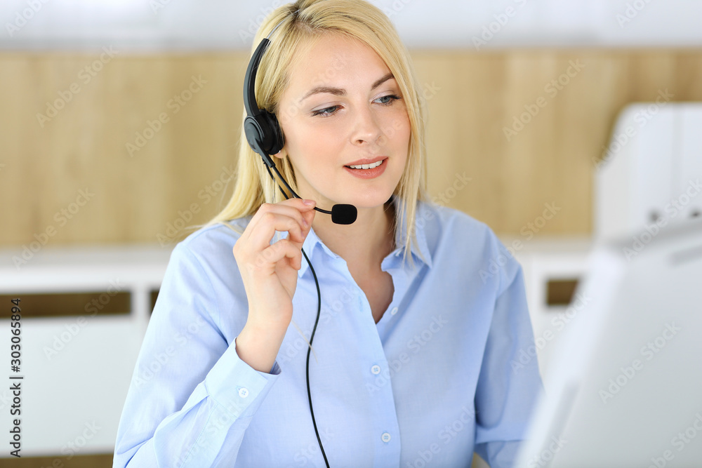 Call center. Blonde business woman sitting in headset at customer service office. Concept of telesales business or home office occupation Call center. Blonde business woman sitting in headset at customer service office. Concept of telesales business or home office occupation