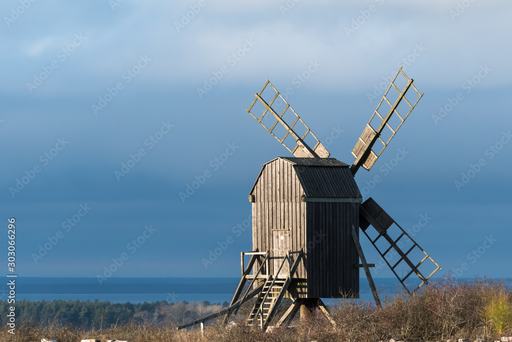 Old wooden windmill in sunlight by fall season