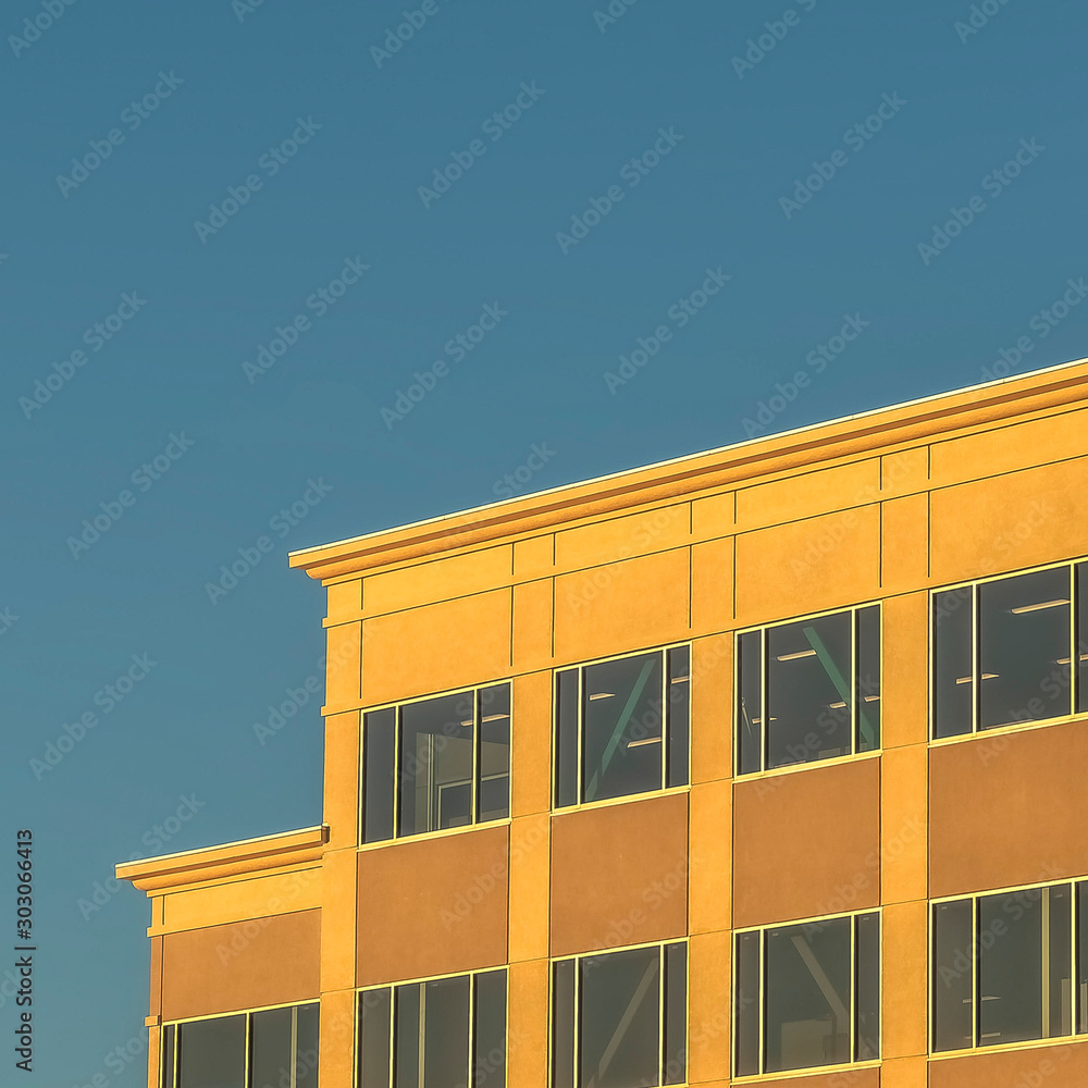 Square Commercial building exterior with mountain and sky background on a sunny day