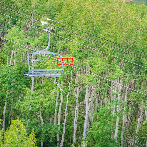 Square Scenic view of trees and hiking trails from a chairlift at Park City off season