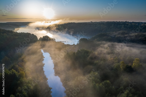Aerial view of fog over river with rays in autumn