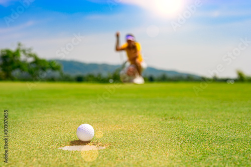 Golf ball did not follow through to the golf hole, putting unsuccessfully reach to the hole, lost in putting by woman golf player, upset or disaster putting of woman player