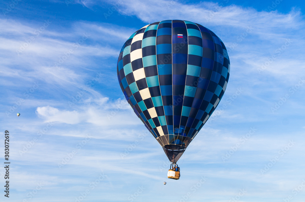 Naklejka premium Hot air a balloon with a scorched envelope against a blue sky