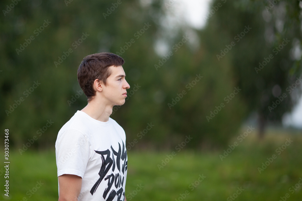 Portrait of a handsome serious guy on a background of trees, Portrait of a handsome serious guy on a background of trees,