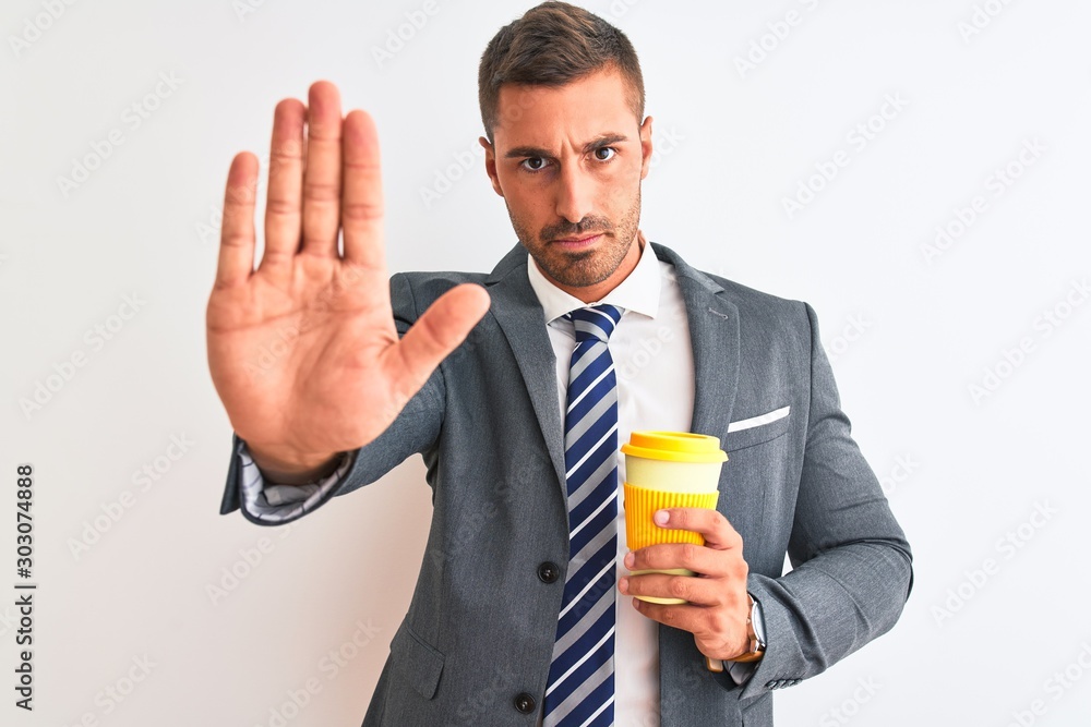Young handsome business man drinking take away coffee over isolated background with open hand doing stop sign with serious and confident expression, defense gesture Young handsome business man drinking take away coffee over isolated background with open hand doing stop sign with serious and confident expression, defense gesture