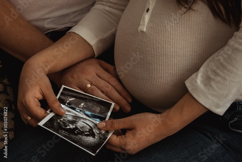 parents expecting a baby admiring photos ultrasound