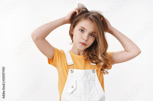 Foto Tender lovely young blond girl in summer dungarees over yellow t-shirt, look tho