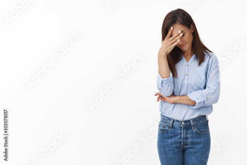 Bild auf Leinwand Embarrassed annoyed adult woman hiding face bend head down, facepalm, smirk irri