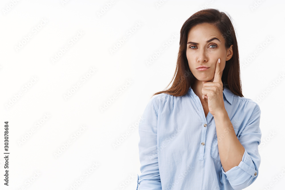 Portrait of thoughtful middle aged woman touches face gently