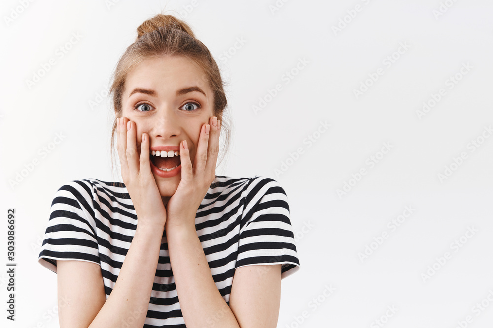 Close-up excited, amused good-looking woman with messy bun, striped t-shirt, scream from excitement and amazement react to wonderful, awesome news, standing white background astonished Close-up excited, amused good-looking woman with messy bun, striped t-shirt, scream from excitement and amazement react to wonderful, awesome news, standing white background astonished