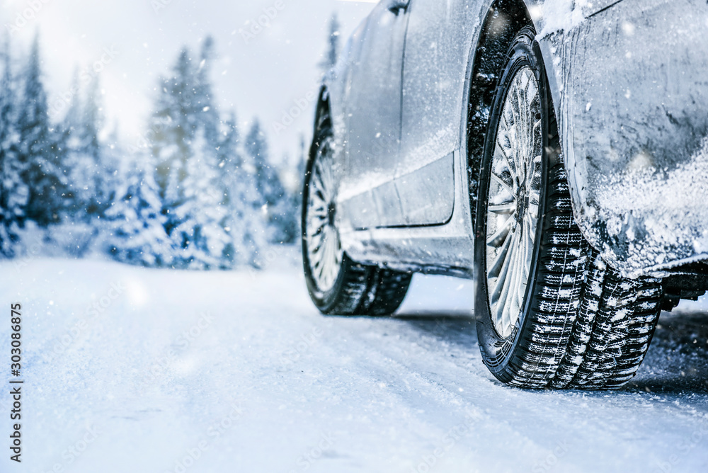 Winter tire. Car tire on snow road. Tires on snowy road detail.