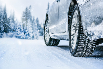 Winter tire. Car tire on snow road. Tires on snowy road detail.