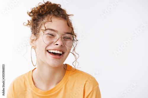 Fototapeta Carefree joyful happy young lucky redhead girl wearing glasses messy curly bun h
