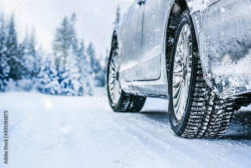 Winter tire. Car tire on snow road. Tires on snowy road detail.
