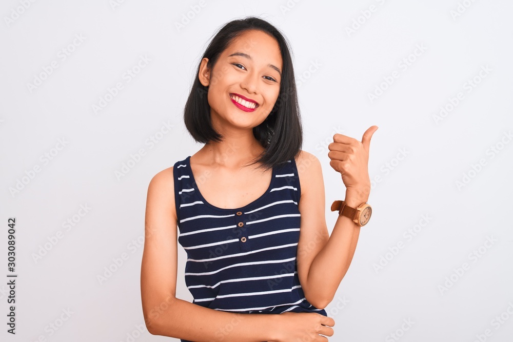 Young chinese woman wearing striped t-shirt standing over isolated white background doing happy thumbs up gesture with hand. Approving expression looking at the camera showing success. Young chinese woman wearing striped t-shirt standing over isolated white background doing happy thumbs up gesture with hand. Approving expression looking at the camera showing success.