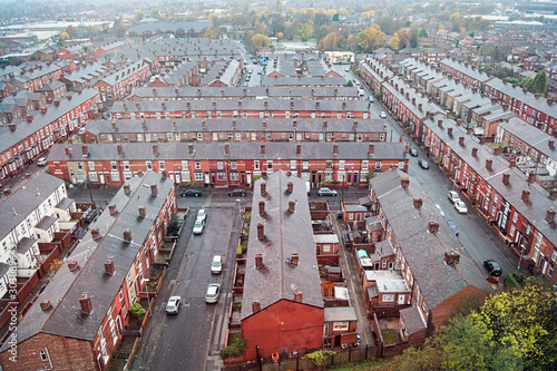 An aerial view of the roof tops, streets and roads of the Manchester district of Gorton. Tightly packed terraced housing, typical of many northern English cities..