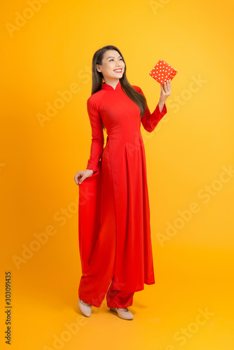 Beautiful woman in red ao dai dress holding gift box