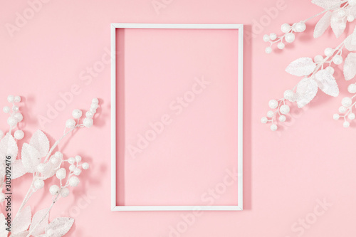 Christmas minimal composition. Photo frame and white decorations on pastel pink background. New Year, winter concept. Flat lay, top view, copy space © prime1001