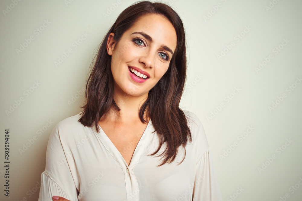 Young beautiful woman wearing casual shirt standing over white isolated background happy face smiling with crossed arms looking at the camera. Positive person. Young beautiful woman wearing casual shirt standing over white isolated background happy face smiling with crossed arms looking at the camera. Positive person.