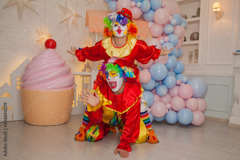 Fototapeta premium Funny clowns from the circus. Clown boy and clown girl show emotions