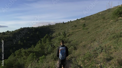 Shadow of someone walking in the mountains on a sunny day with rocks on the side of the hill photo