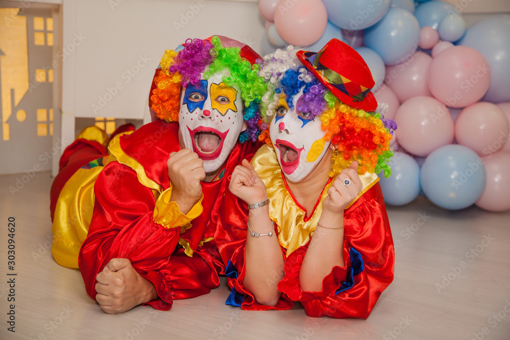 Funny clowns from the circus. Clown boy and clown girl show emotions Funny clowns from the circus. Clown boy and clown girl show emotions