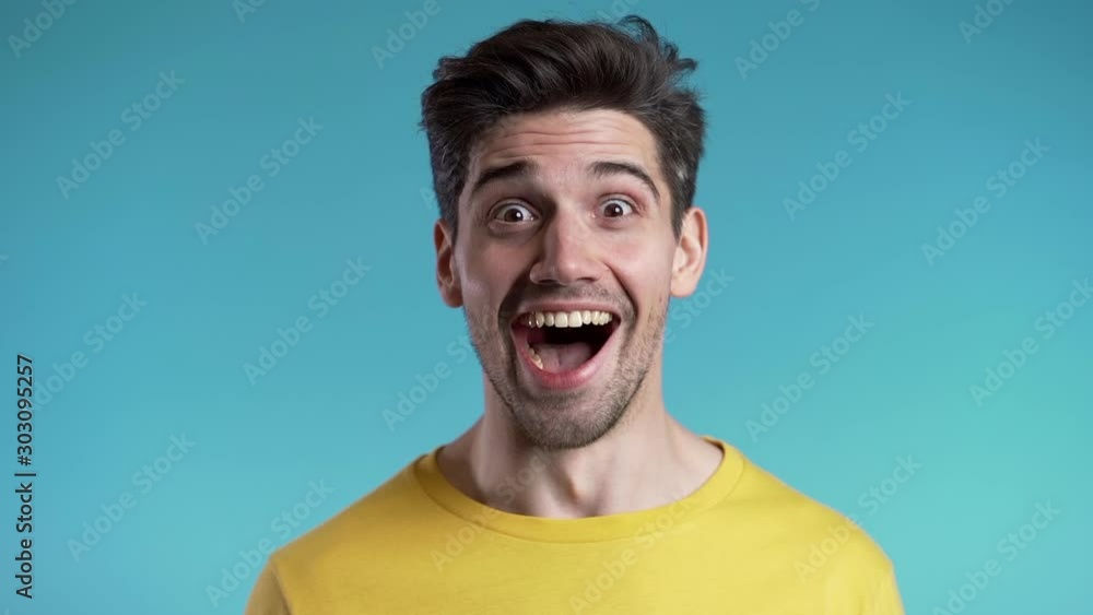 Amazed european man shocked, saying WOW. Handsome guy with stylish hairdo surprised to camera over blue background. Amazed european man shocked, saying WOW. Handsome guy with stylish hairdo surprised to camera over blue background.