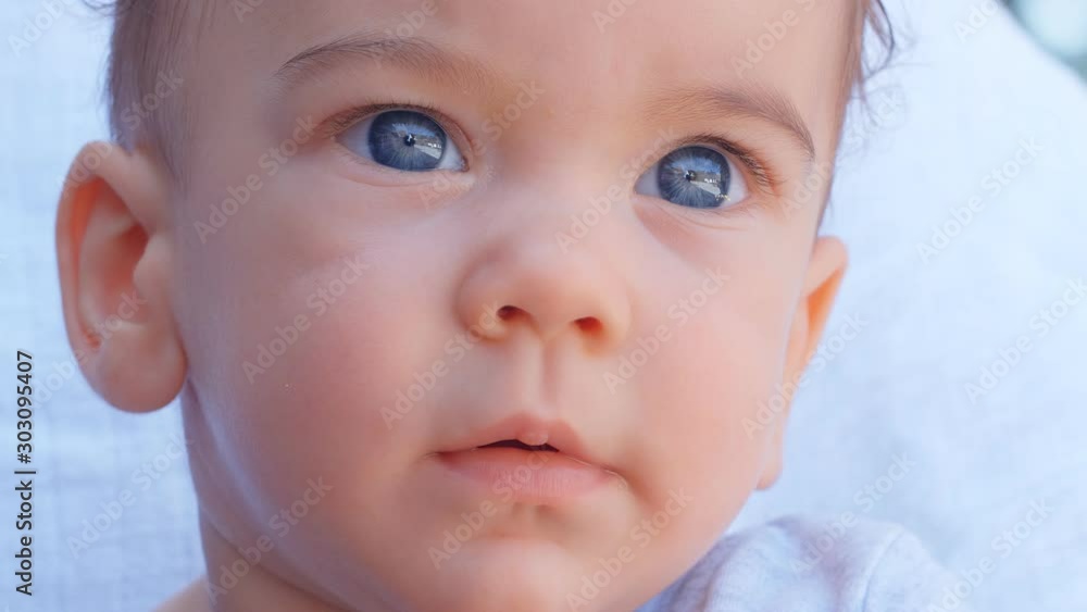 Closeup portrait of 6 months baby boy face. Concept of caring for children and parental love, 4k slow motion Closeup portrait of 6 months baby boy face. Concept of caring for children and parental love, 4k slow motion