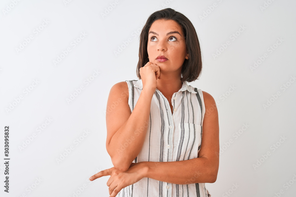 Young beautiful woman wearing casual striped shirt standing over isolated white background with hand on chin thinking about question, pensive expression. Smiling with thoughtful face. Doubt concept. Young beautiful woman wearing casual striped shirt standing over isolated white background with hand on chin thinking about question, pensive expression. Smiling with thoughtful face. Doubt concept.