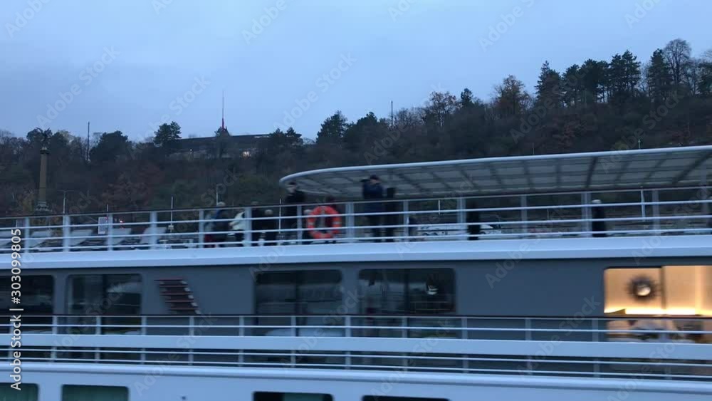Closeup of passing Vltava river cruise-ship with passengers waving Closeup of passing Vltava river cruise-ship with passengers waving