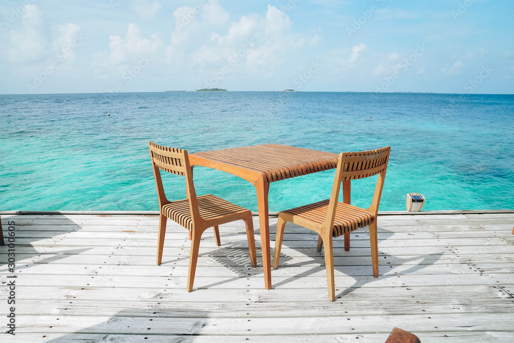 Outdoor terrace with Empty  wooden table and chair with Sea view of Indain ocean, Maldives background