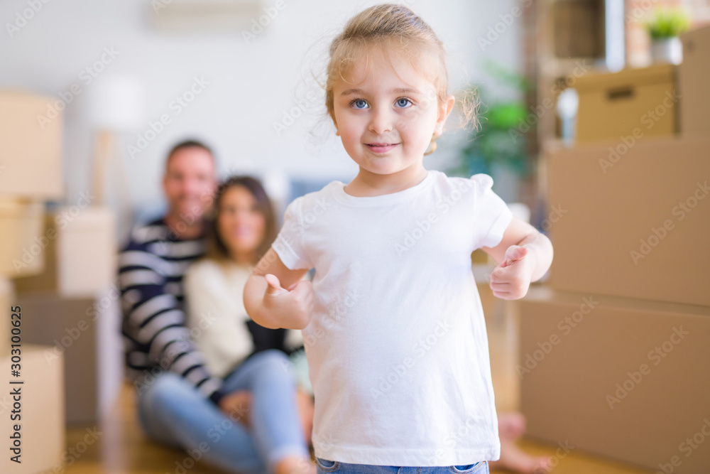 Beautiful family sitting on the floor playing with his kid at new home around cardboard boxes Beautiful family sitting on the floor playing with his kid at new home around cardboard boxes