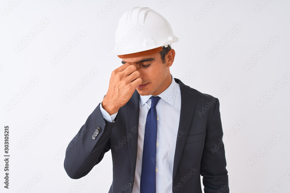 Young handsome architect man wearing suit and helmet over isolated white background tired rubbing nose and eyes feeling fatigue and headache. Stress and frustration concept. Young handsome architect man wearing suit and helmet over isolated white background tired rubbing nose and eyes feeling fatigue and headache. Stress and frustration concept.