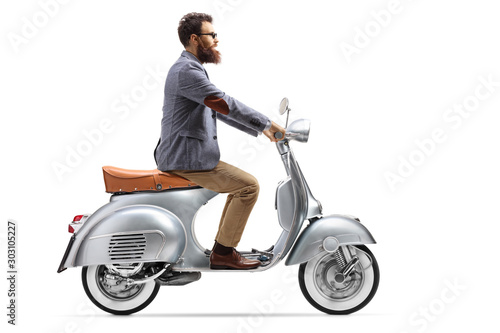 Profile shot of a bearded guy on a vintage scooter