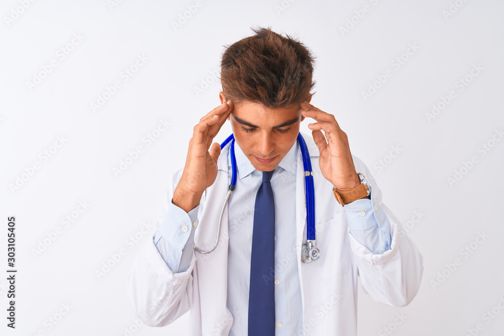 Young handsome doctor man wearing stethoscope over isolated white background with hand on head for pain in head because stress. Suffering migraine. Young handsome doctor man wearing stethoscope over isolated white background with hand on head for pain in head because stress. Suffering migraine.