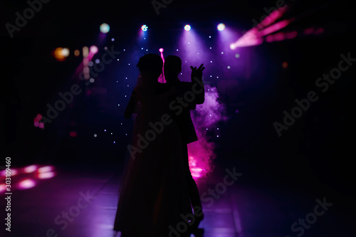 The first wedding dance of the newlyweds..Silhouettes of loving couple in the dark