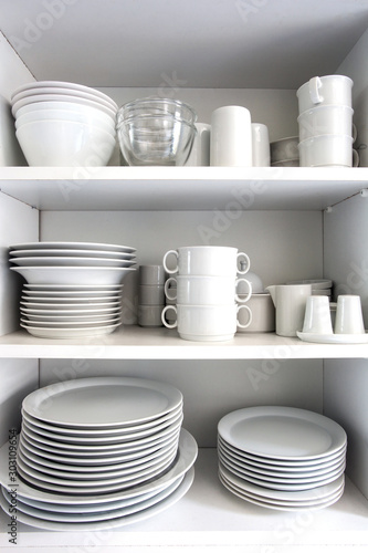 White Cupboard with white crockery in the kitchen, various clean dishes