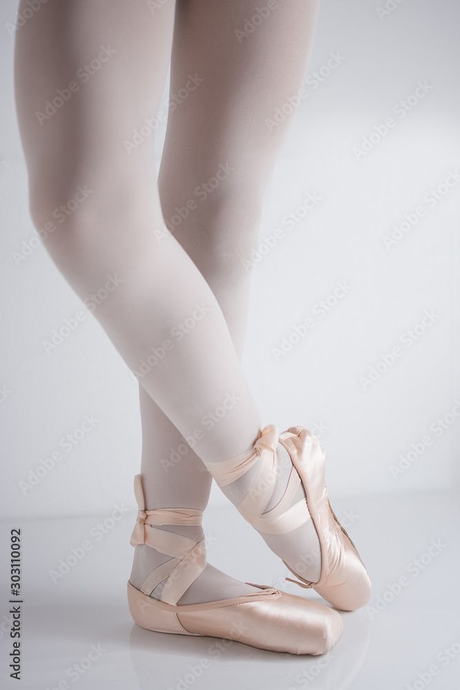 Fototapeta premium legs and feet with pink satin pointe shoes by a classical dancer posing