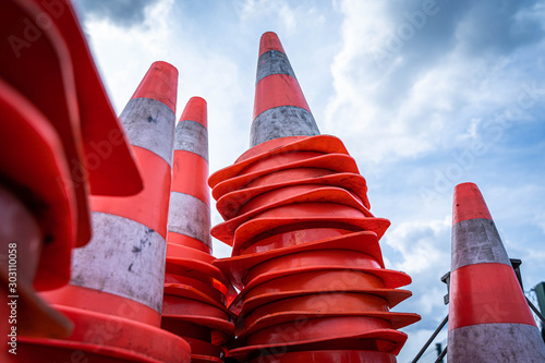Closeup of traffic cones in front of blue cloudy sky