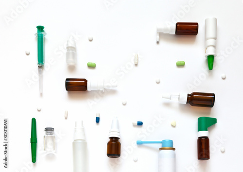 Medications for common cold, viral infections and seasonal diseases. Sprays and drops for nose, pills and capsules against temperature, inhaler for throat on white background. Flat lay, mock up