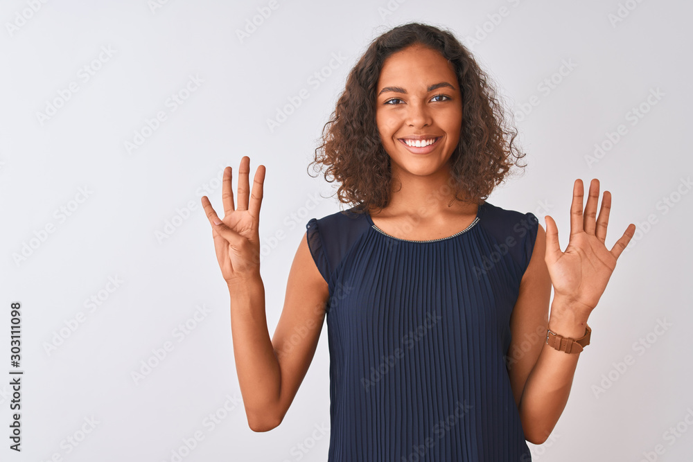 Young brazilian woman wearing blue dress standing over isolated white background showing and pointing up with fingers number nine while smiling confident and happy. Young brazilian woman wearing blue dress standing over isolated white background showing and pointing up with fingers number nine while smiling confident and happy.
